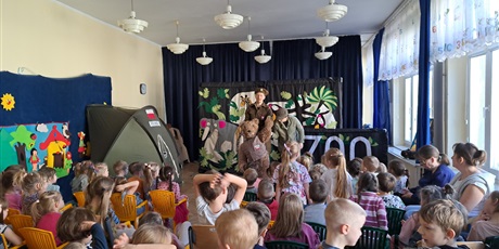 Powiększ grafikę: Na zdjęciu dzieci w wieku przedszkolnym podczas  przedstawienia w oddali namiot oraz pluszowy miś i dwoje żołnierzy