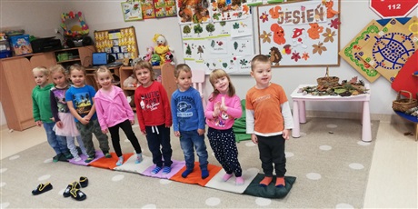 Powiększ grafikę: Dzieci stoją w rzędzie na materiałowej ścieżce sensorycznej