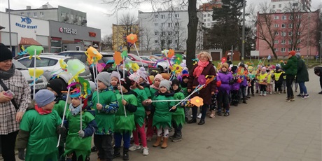 Powiększ grafikę: Na zdjęciu grupa dzieci w wieku przedszkolnym w strojach zielonych z kwiatkami  witająca wiosnę