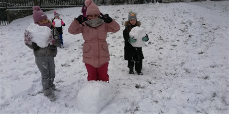 Powiększ grafikę: Dzieci podczas zabaw na śniegu toczący kulę śnieżną